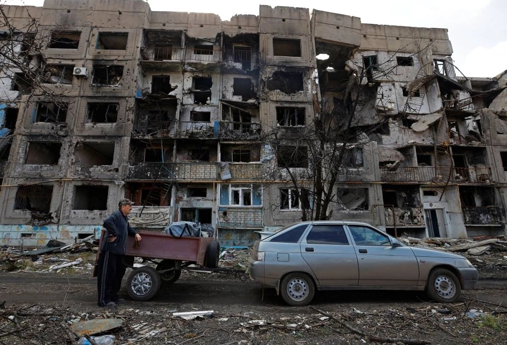 A local resident stands next to a car in front of a residential building heavily damaged in the course of the Russia-Ukraine war, in the settlement of Toshkivka, in the Luhansk province of Russian-controlled Ukraine on March 24. A local resident stands next to a car in front of a residential building heavily damaged in the course of the Russia-Ukraine war, in the settlement of Toshkivka, in the Luhansk province of Russian-controlled Ukraine on March 24.