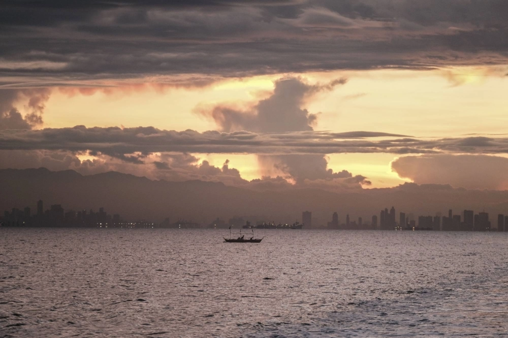 Fishermen ride wooden boats in Manila Bay, the Philippines, in June. Fishermen ride wooden boats in Manila Bay, the Philippines, in June.