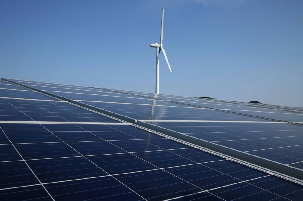 A wind turbine stands next to solar panels at a Banpu Power solar plant in Awaji, Hyogo Prefecture. A wind turbine stands next to solar panels at a Banpu Power solar plant in Awaji, Hyogo Prefecture.