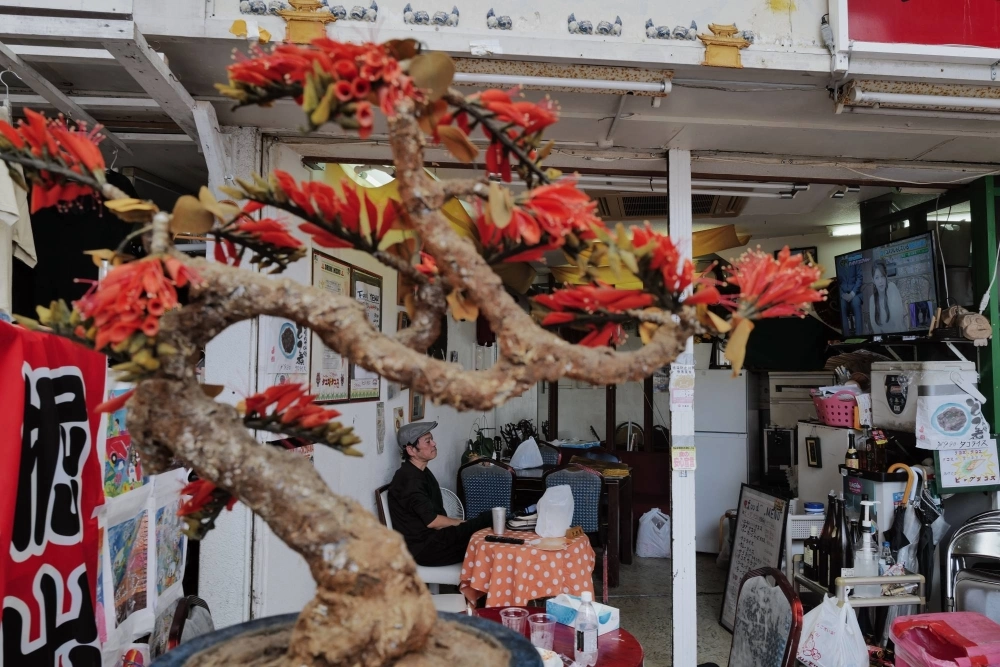 A man sits on his own at a taco stand on Kokusai Street in Naha.  A man sits on his own at a taco stand on Kokusai Street in Naha.