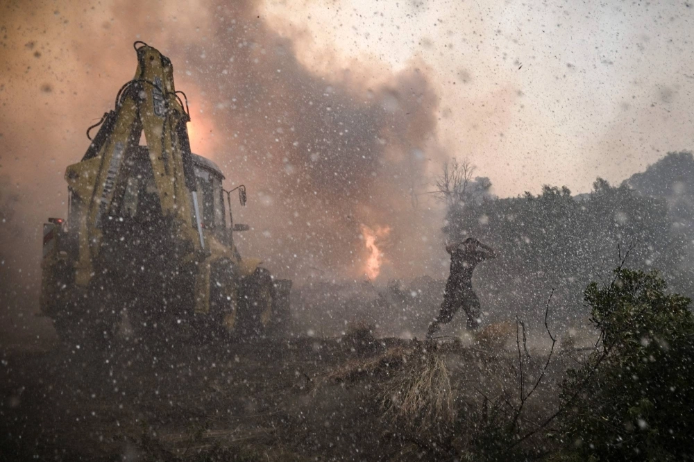 A helicopter sprays water over a fire on the southern part of the Greek island of Rhodes on Tuesday. Wildfires have been raging in Greece amid scorching temperatures, forcing mass evacuations in several tourist spots including on the islands of Rhodes and Corfu. A helicopter sprays water over a fire on the southern part of the Greek island of Rhodes on Tuesday. Wildfires have been raging in Greece amid scorching temperatures, forcing mass evacuations in several tourist spots including on the islands of Rhodes and Corfu.