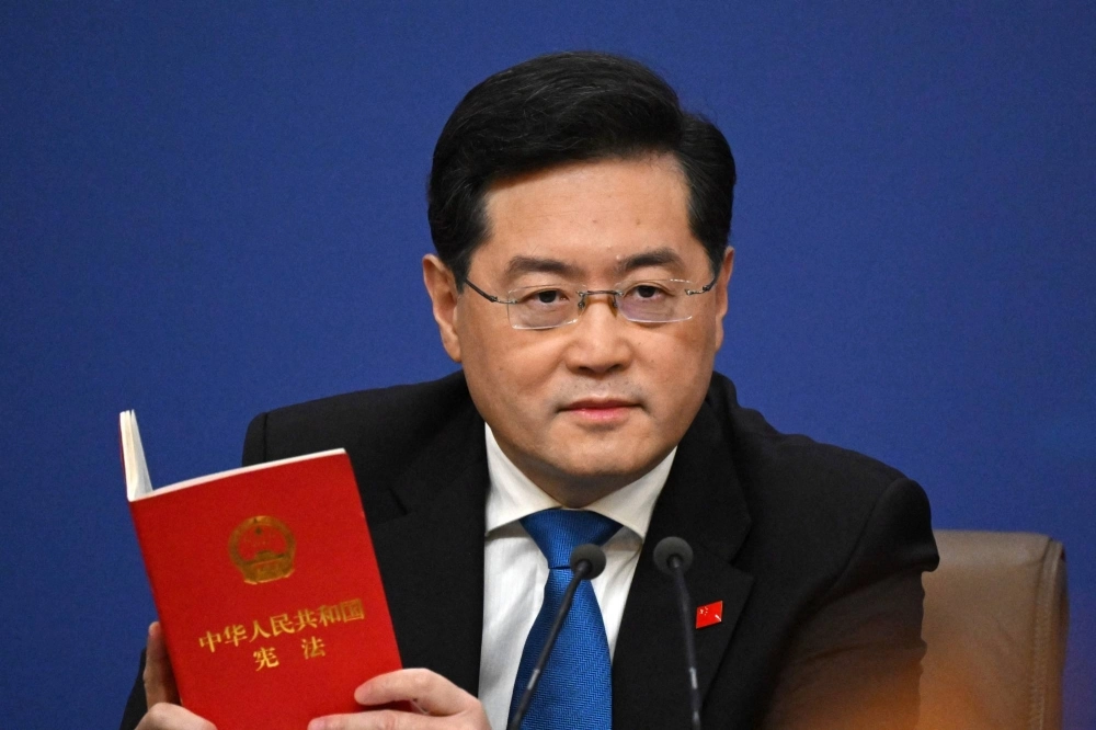Then-Chinese Foreign Minister Qin Gang holds a copy of China's constitution during a news conference at the National People's Congress in Beijing in March. Then-Chinese Foreign Minister Qin Gang holds a copy of China's constitution during a news conference at the National People's Congress in Beijing in March.