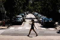 A pedestrian crosses a street during a heat wave in Philadelphia on Friday. Scientists suspect the last several years have been warmer than any point in more than 125,000 years. | Bloomberg