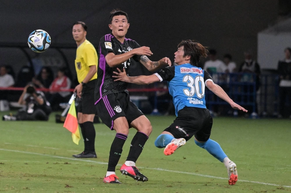 Bayern defender Kim Min-jae (center) and Frontale forward Yusuke Segawa (right) contend for the ball during an international friendly at the National Stadium on Saturday. Bayern defender Kim Min-jae (center) and Frontale forward Yusuke Segawa (right) contend for the ball during an international friendly at the National Stadium on Saturday.