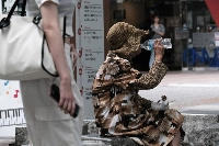 A woman drinks a bottle of water near Fukushima Station in the city of Fukushima on July 6. | Bloomberg