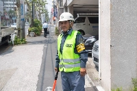 An 81-year-old traffic guard keeps watch at a construction site in Tokyo's Sumida Ward on July 19. | Louise Claire WAGNER