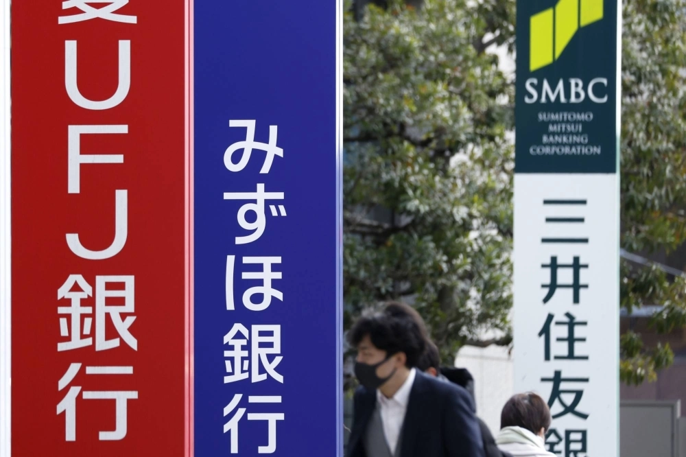 Signage for Sumitomo Mitsui Banking (right) and Mizuho Bank (center) in Tokyo. Two of Japan's mega-banks reported solid quarterly profit on Monday. Signage for Sumitomo Mitsui Banking (right) and Mizuho Bank (center) in Tokyo. Two of Japan's mega-banks reported solid quarterly profit on Monday.