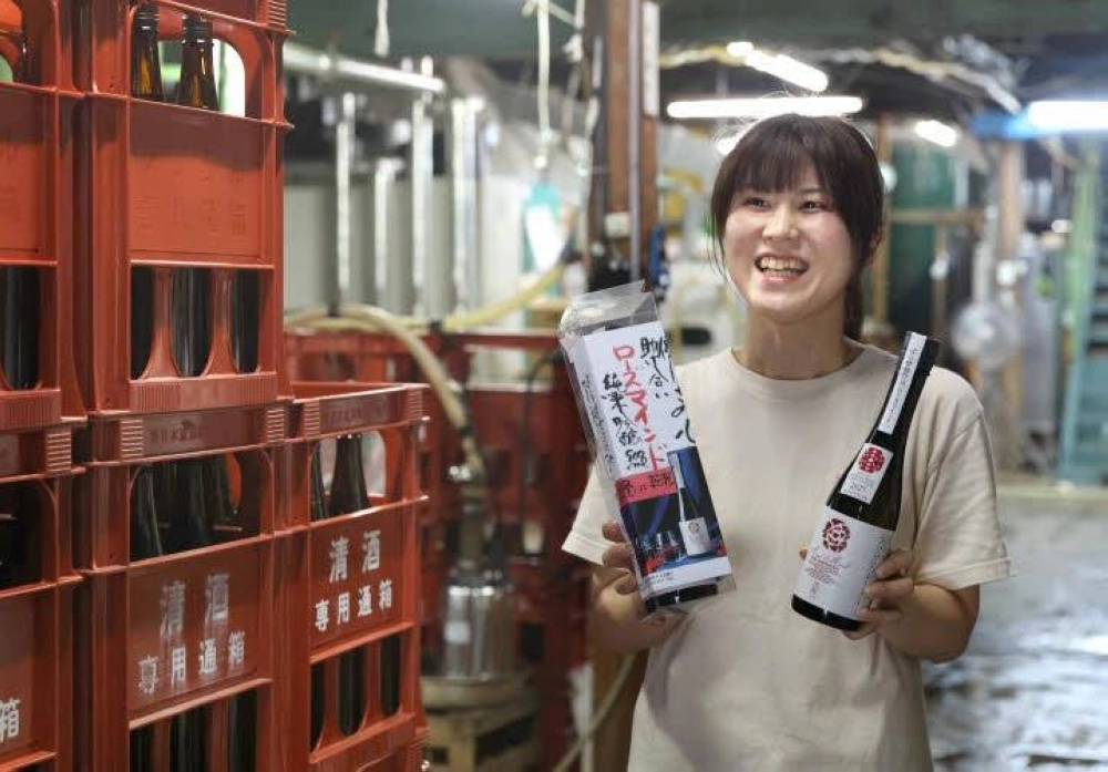 Chikako Utsumi holds bottles of Rose Mind at Tenpoichi sake brewer in Fukuyama, Hiroshima Prefecture. Chikako Utsumi holds bottles of Rose Mind at Tenpoichi sake brewer in Fukuyama, Hiroshima Prefecture.