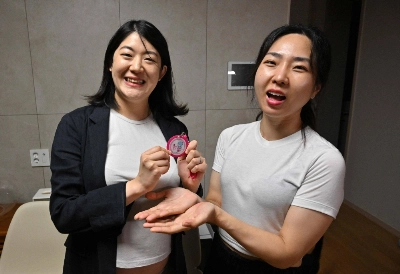 South Korean lesbian couple Kim Kyu-jin (left) and her wife, Kim Sae-yeon, pose with a "pregnant woman" badge during an interview in Seoul last month. South Korean lesbian couple Kim Kyu-jin (left) and her wife, Kim Sae-yeon, pose with a "pregnant woman" badge during an interview in Seoul last month.