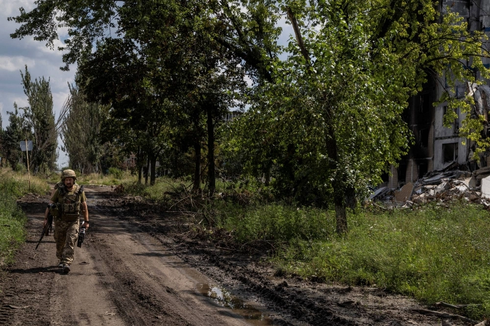 Ukrainian servicemen walk near buildings damaged by a Russian military strike in the city of Vuhledar in the Donetsk region, Ukraine, on Friday. Ukrainian servicemen walk near buildings damaged by a Russian military strike in the city of Vuhledar in the Donetsk region, Ukraine, on Friday.