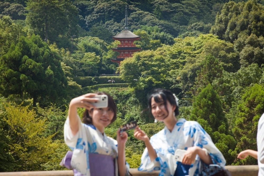 Kimono-clad visitors take selfie photographs at Kiyomizu Temple in Kyoto on Friday. Kimono-clad visitors take selfie photographs at Kiyomizu Temple in Kyoto on Friday.
