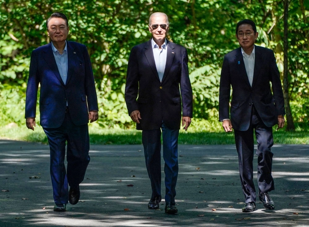 U.S. President Joe Biden walks with Prime Minister Fumio Kishida and South Korean leader Yoon Suk-yeol as the three arrive for a joint news conference during a trilateral summit at Camp David, near Thurmont, Maryland, on Friday. U.S. President Joe Biden walks with Prime Minister Fumio Kishida and South Korean leader Yoon Suk-yeol as the three arrive for a joint news conference during a trilateral summit at Camp David, near Thurmont, Maryland, on Friday.