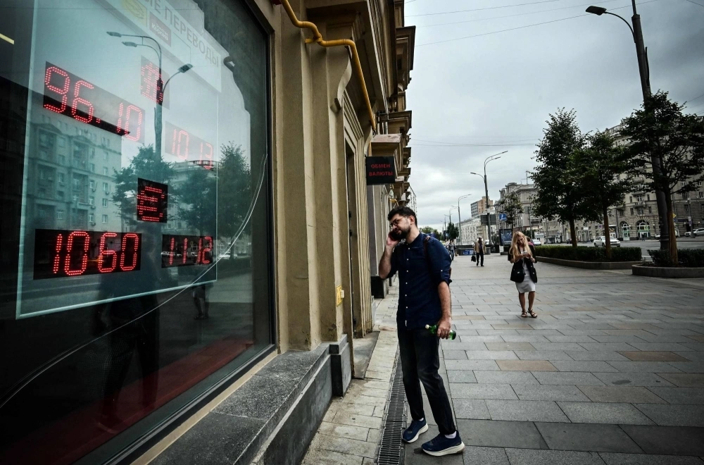 A man examines the rates at a currency exchange office in Moscow on Monday. A man examines the rates at a currency exchange office in Moscow on Monday.