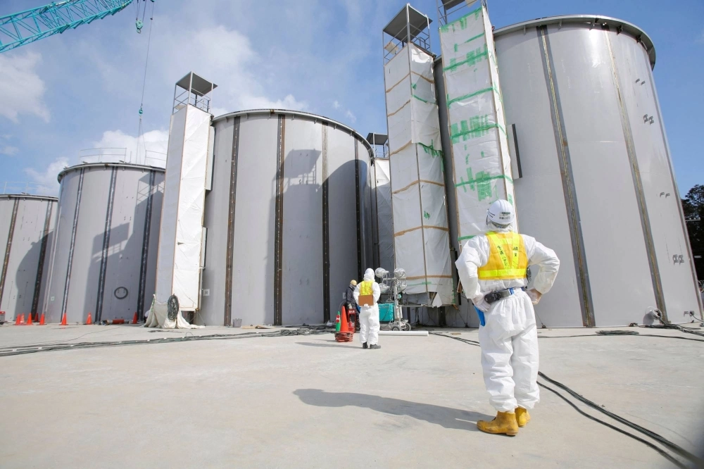 Workers perform tasks near storage tanks for treated water under construction at the crippled Fukushima No. 1 nuclear power plant in Fukushima prefecture in 2014. Workers perform tasks near storage tanks for treated water under construction at the crippled Fukushima No. 1 nuclear power plant in Fukushima prefecture in 2014.