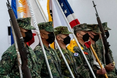 Members of the Philippines, Japan, South Korea, and U.S. armed forces carry national flags during the opening ceremony of joint military exercises in Taguig, Philippines, in October 2022.  Members of the Philippines, Japan, South Korea, and U.S. armed forces carry national flags during the opening ceremony of joint military exercises in Taguig, Philippines, in October 2022.