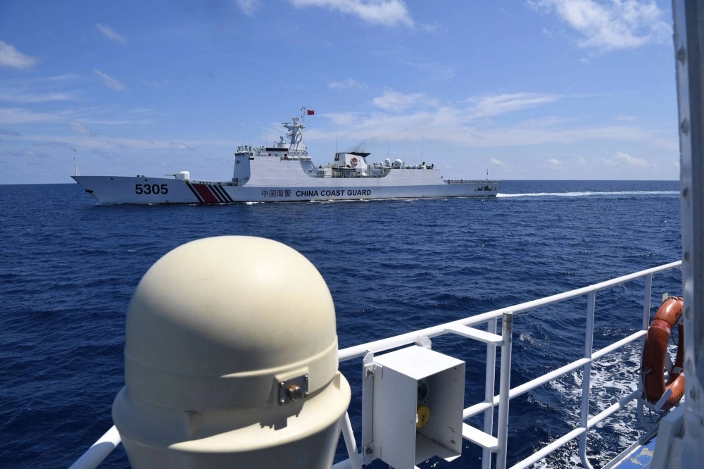 A Chinese coast guard ship (top) shadows a Philippine re-supply vessel on Tuesday in the disputed South China Sea.    A Chinese coast guard ship (top) shadows a Philippine re-supply vessel on Tuesday in the disputed South China Sea.