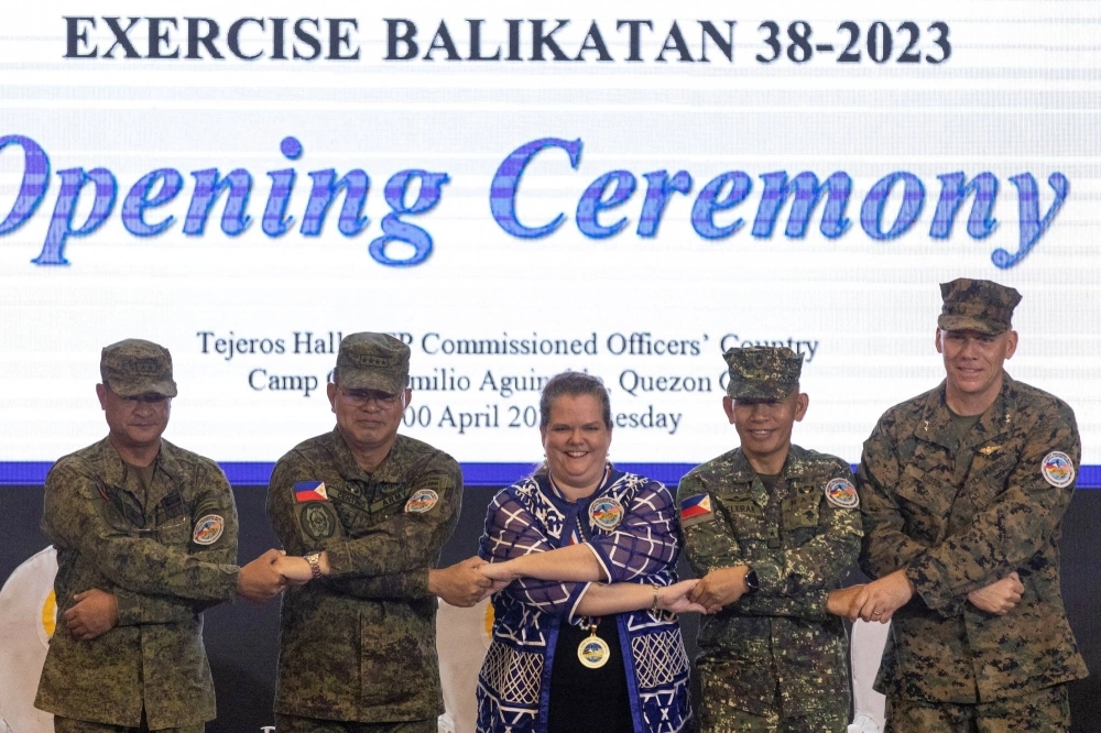 U.S and Philippine military officials link arms with U.S. Embassy representative Heather Variava during the opening ceremony of the annual Philippines-U.S. joint military exercises at the Armed Forces of the Philippines headquarters in Quezon City, Metro Manila, Philippines, on April 11. U.S and Philippine military officials link arms with U.S. Embassy representative Heather Variava during the opening ceremony of the annual Philippines-U.S. joint military exercises at the Armed Forces of the Philippines headquarters in Quezon City, Metro Manila, Philippines, on April 11.