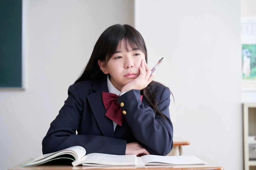 A Japanese junior high school student stares off into space while in the classroom. If your child is distracted or preoccupied during lessons, it may be time to speak with their teacher. A Japanese junior high school student stares off into space while in the classroom. If your child is distracted or preoccupied during lessons, it may be time to speak with their teacher.