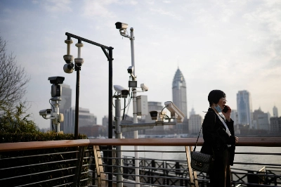 A woman stands under surveillance cameras on a riverside, during the National People's Congress in Shanghai on March 7. A woman stands under surveillance cameras on a riverside, during the National People's Congress in Shanghai on March 7.