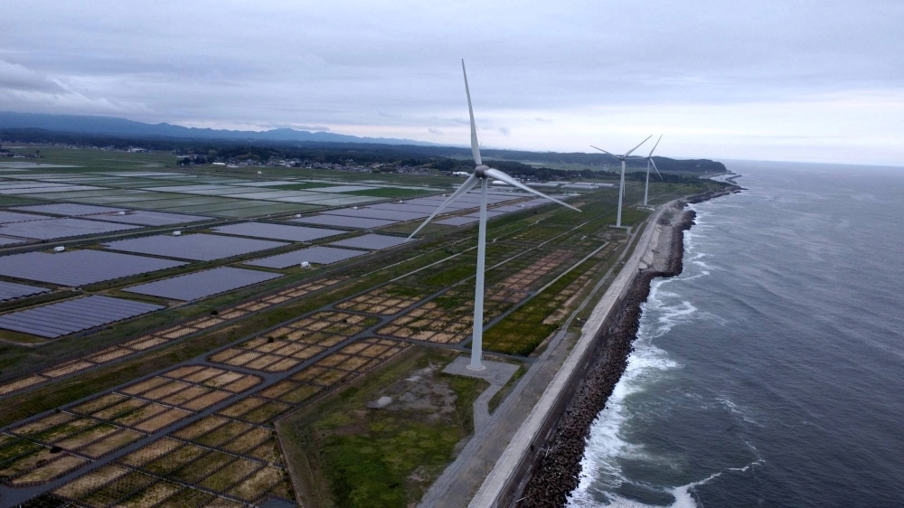 Nestled behind a seawall on the Pacific coast are the Minamisoma Mano-Migita-Ebi solar power plant and the Manyo no Sato wind farm. The 2011 tsunami struck this portion of the coast with a wave that is reported to have been around 18 meters high. Nestled behind a seawall on the Pacific coast are the Minamisoma Mano-Migita-Ebi solar power plant and the Manyo no Sato wind farm. The 2011 tsunami struck this portion of the coast with a wave that is reported to have been around 18 meters high.