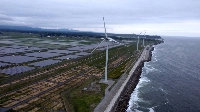 Nestled behind a seawall on the Pacific coast are the Minamisoma Mano-Migita-Ebi solar power plant and the Manyo no Sato wind farm. The 2011 tsunami struck this portion of the coast with a wave that is reported to have been around 18 meters high. | Francesco Bassetti