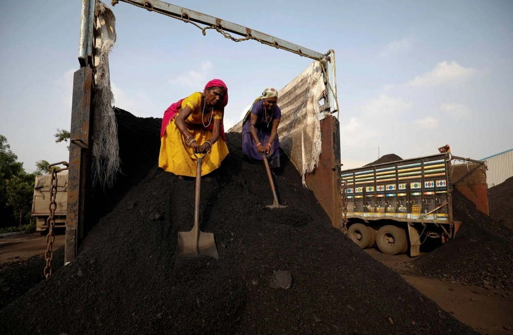 Workers unload coal from a supply truck at a yard on the outskirts of Ahmedabad, India. Workers unload coal from a supply truck at a yard on the outskirts of Ahmedabad, India.