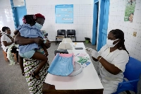 A nurse prepares to take care of a child with malaria at a hospital in Abidjan, Ivory Coast. | REUTERS
