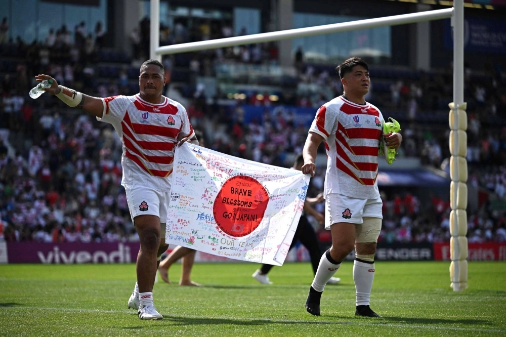 Japan's Asaeli Ai Valu (left) and Atsushi Sakate celebrate with a Japanese flag after defeating Chile in their opening game of the Rugby World Cup in Toulouse, France, on Sept. 10. Japan's Asaeli Ai Valu (left) and Atsushi Sakate celebrate with a Japanese flag after defeating Chile in their opening game of the Rugby World Cup in Toulouse, France, on Sept. 10.