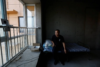 Shi Tieniu, 39, sits in a room of an unfinished residential building at Gaotie Wellness City complex in Tongchuan, Shaanxi province, China. Shi Tieniu, 39, sits in a room of an unfinished residential building at Gaotie Wellness City complex in Tongchuan, Shaanxi province, China.