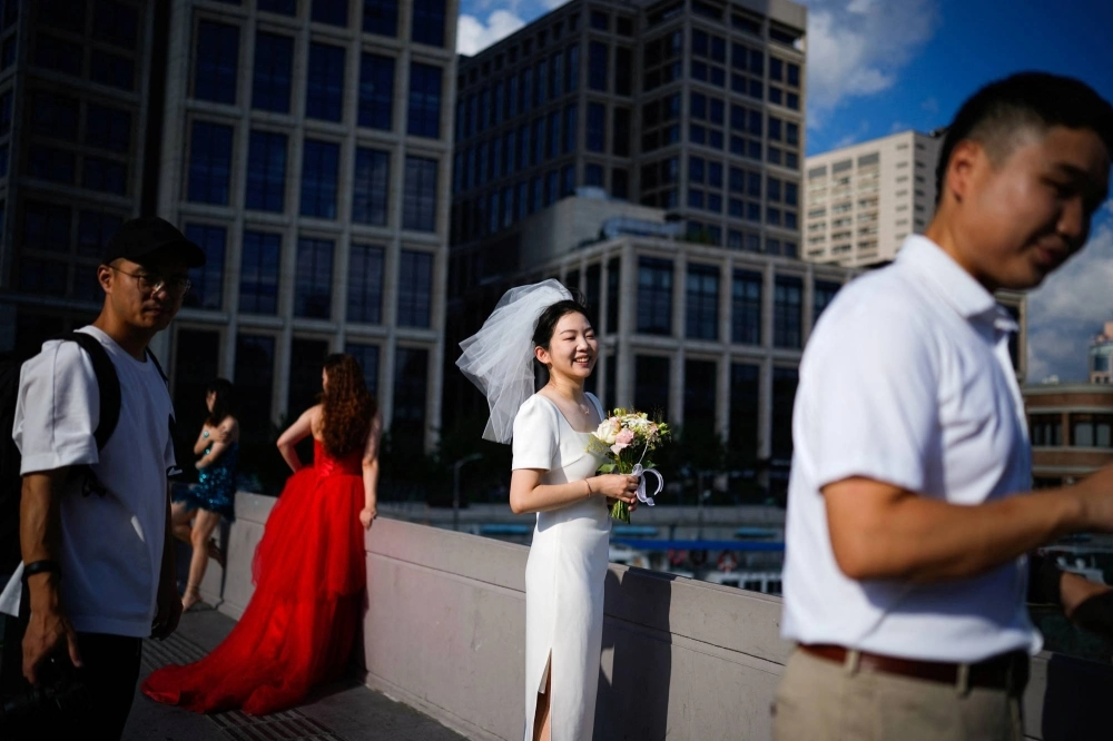 Couples prepare to have their photo taken during a wedding photography shoot on a in Shanghai on Sept. 6. Couples prepare to have their photo taken during a wedding photography shoot on a in Shanghai on Sept. 6.