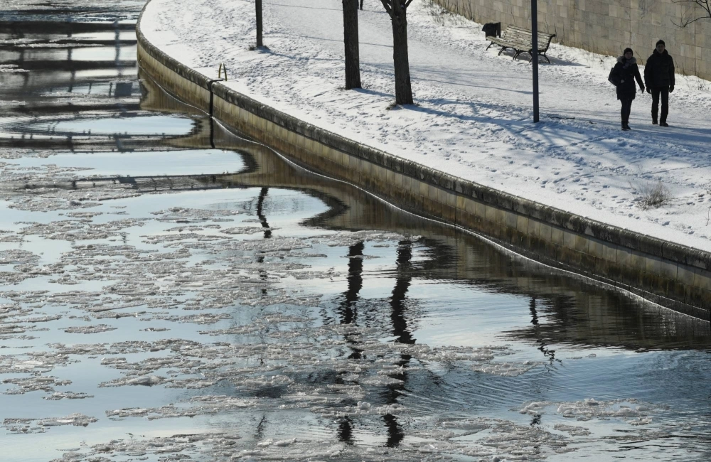People walk on the bank of the frozen Spree river in Berlin in 2021. People walk on the bank of the frozen Spree river in Berlin in 2021.