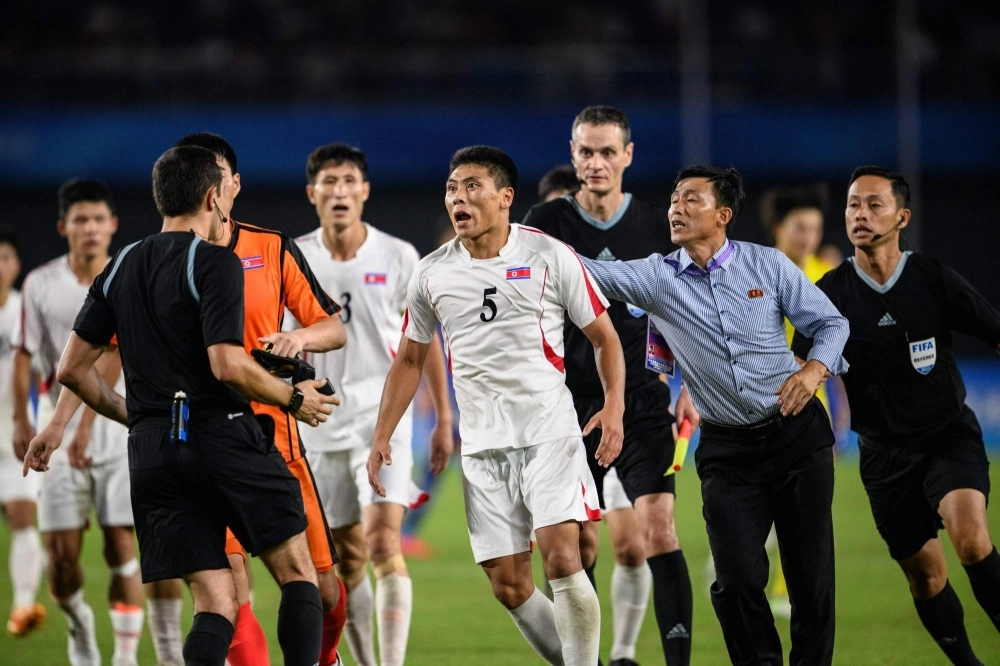 North Korea's Kim Kyong Sok (center) reacts after the men's quarterfinal football match between North Korea and Japan at the Asian Games in Hangzhou, China, on Sunday. North Korea's Kim Kyong Sok (center) reacts after the men's quarterfinal football match between North Korea and Japan at the Asian Games in Hangzhou, China, on Sunday.