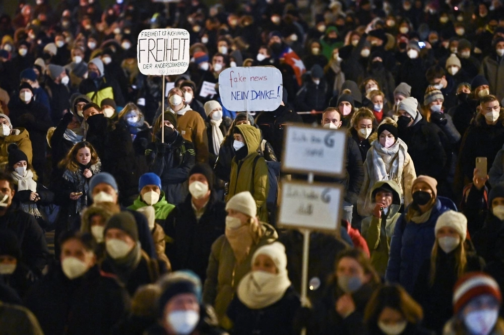 Demonstrators hold signs during a protest against COVID-19 measures Munich in 2022. Demonstrators hold signs during a protest against COVID-19 measures Munich in 2022.