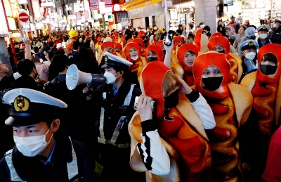 Police officers work to control a crowd gathering to celebrate Halloween in the Shibuya district of Tokyo on Oct. 31, 2022. Police officers work to control a crowd gathering to celebrate Halloween in the Shibuya district of Tokyo on Oct. 31, 2022.