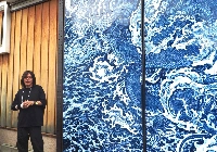 Yuki Hayama tells visitors about his dragon mural, an enlarged print of his ceramic work, showcased on the doors of the Masuda Sake Brewery. | MIO YAMADA