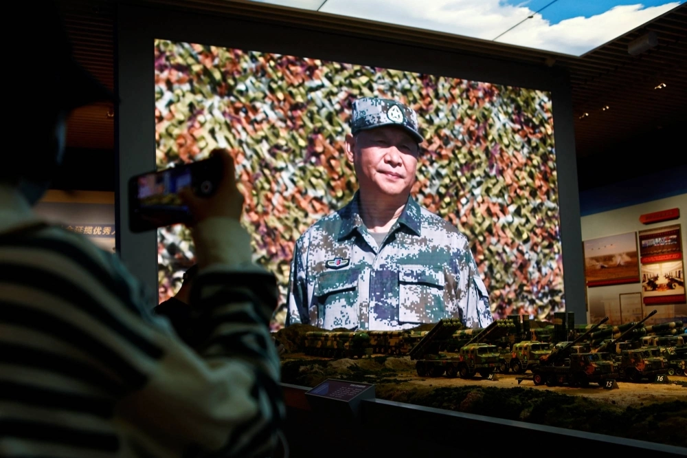 A visitor takes pictures near models of military equipment and a giant screen displaying Chinese leader Xi Jinping, at an exhibition at the Military Museum of the Chinese People's Revolution in Beijing in October last year. A visitor takes pictures near models of military equipment and a giant screen displaying Chinese leader Xi Jinping, at an exhibition at the Military Museum of the Chinese People's Revolution in Beijing in October last year.