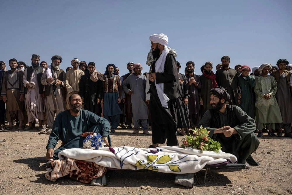 Sher Aqa, left, grieves over the body of his 12-year-old daughter, Roqia, during a funeral in the earthquake-ravaged village of Siaab, in Herat Province, Afghanistan, on Tuesday. Sher Aqa, left, grieves over the body of his 12-year-old daughter, Roqia, during a funeral in the earthquake-ravaged village of Siaab, in Herat Province, Afghanistan, on Tuesday.
