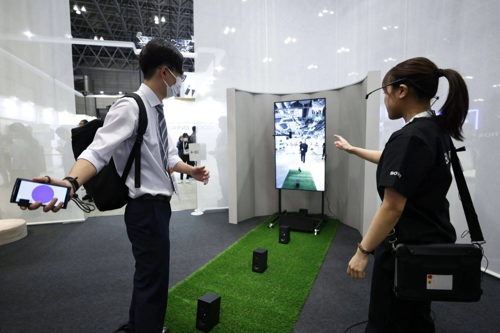 An attendee tries out the XR Catch game at the Sony Group booth at CEATEC in Chiba on Tuesday.  An attendee tries out the XR Catch game at the Sony Group booth at CEATEC in Chiba on Tuesday.