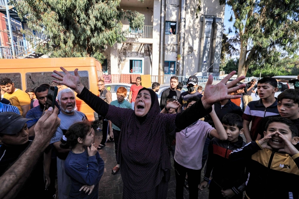 People gather at the site of the al-Ahli al-Arabi hospital in central Gaza on Wednesday in the aftermath of an overnight strike there.  People gather at the site of the al-Ahli al-Arabi hospital in central Gaza on Wednesday in the aftermath of an overnight strike there.