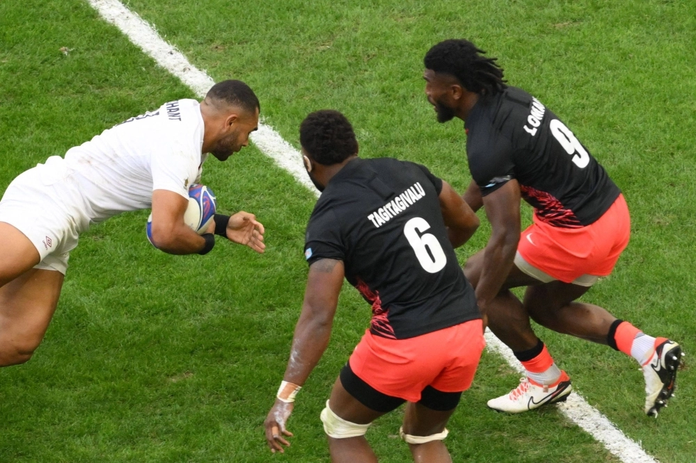 England's outside center Joe Marchant (left) scores a try against Fiji during the quarterfinals of the Rugby World Cup in Marseille, France, on Oct. 15.  England's outside center Joe Marchant (left) scores a try against Fiji during the quarterfinals of the Rugby World Cup in Marseille, France, on Oct. 15.