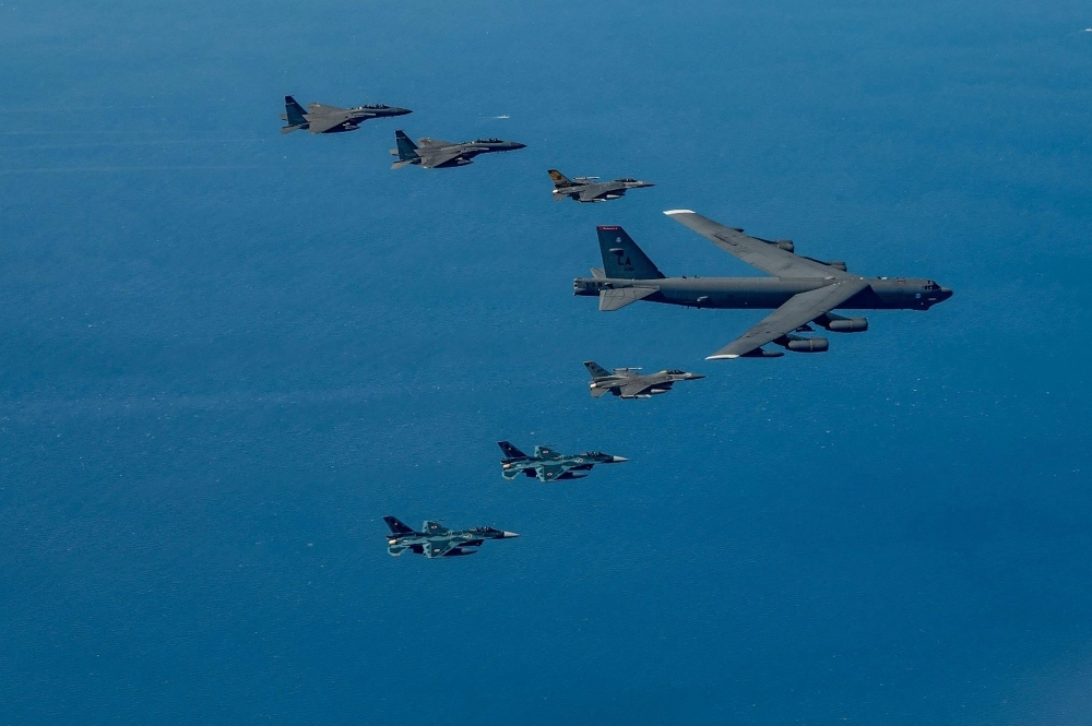 Two Air Self-Defense Force F-2 fighter jets (bottom) fly in formation with a U.S. Air Force B-52 bomber as part of a joint exercise with the United States and South Korea in airspace near Kyushu on Sunday. Two Air Self-Defense Force F-2 fighter jets (bottom) fly in formation with a U.S. Air Force B-52 bomber as part of a joint exercise with the United States and South Korea in airspace near Kyushu on Sunday.