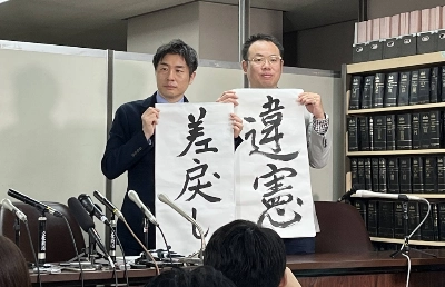 Lawyers Kazuyuki Minami (left) and Masafumi Yoshida (right) representing a transgender woman show off signs that say "unconstitutional" and "sent back" to a lower court, during a news conference Wednesday in Tokyo after a Supreme Court decision. Lawyers Kazuyuki Minami (left) and Masafumi Yoshida (right) representing a transgender woman show off signs that say "unconstitutional" and "sent back" to a lower court, during a news conference Wednesday in Tokyo after a Supreme Court decision.