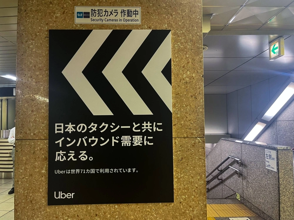 A poster for Uber displayed at a Tokyo subway station reads: "Meeting inbound demand together with Japan's taxis." It also notes that its service is used in 71 countries. A poster for Uber displayed at a Tokyo subway station reads: "Meeting inbound demand together with Japan's taxis." It also notes that its service is used in 71 countries.
