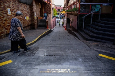 A woman walks past newly unveiled lettering that references the Oct. 29 Itaewon crush in Seoul. A more fully developed memorial was later built to commemorate the event and the more than 150 people who lost their lives.  A woman walks past newly unveiled lettering that references the Oct. 29 Itaewon crush in Seoul. A more fully developed memorial was later built to commemorate the event and the more than 150 people who lost their lives.
