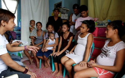 A community health worker speaks during a meeting with pregnant teenagers, teen mothers and their partners, in Navotas, Metro Manila, in 2016.  A community health worker speaks during a meeting with pregnant teenagers, teen mothers and their partners, in Navotas, Metro Manila, in 2016.