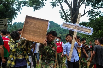 People carry a coffin as a mass funeral takes place to bury victims of a military strike on a camp for displaced people near the northern Myanmar town of Laiza on Oct. 10. People carry a coffin as a mass funeral takes place to bury victims of a military strike on a camp for displaced people near the northern Myanmar town of Laiza on Oct. 10.