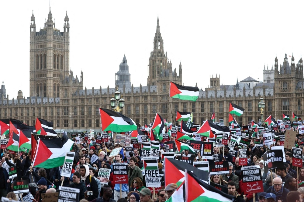Protesters wave Palestinian flags as they walk over Westminster Bridge near the Houses of Parliament in London on Saturday. 
 Protesters wave Palestinian flags as they walk over Westminster Bridge near the Houses of Parliament in London on Saturday.