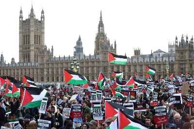 Protesters wave Palestinian flags as they walk over Westminster Bridge near the Houses of Parliament in London on Saturday. 
 Protesters wave Palestinian flags as they walk over Westminster Bridge near the Houses of Parliament in London on Saturday.