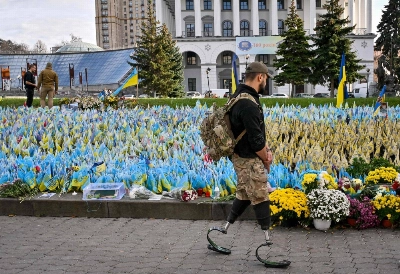 A serviceman, wearing prosthetic legs, walks past Ukrainian flags symbolizing fallen soldiers on the Independence Square in Kyiv, on Oct. 30. A serviceman, wearing prosthetic legs, walks past Ukrainian flags symbolizing fallen soldiers on the Independence Square in Kyiv, on Oct. 30.