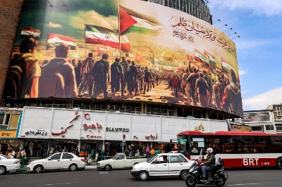 Motorists drive past a giant billboard depicting Muslim people walking with their national flags toward the Dome of the Rock shrine in Jerusalem, in central Tehran's Valiasr Square on Oct. 25. Motorists drive past a giant billboard depicting Muslim people walking with their national flags toward the Dome of the Rock shrine in Jerusalem, in central Tehran's Valiasr Square on Oct. 25.